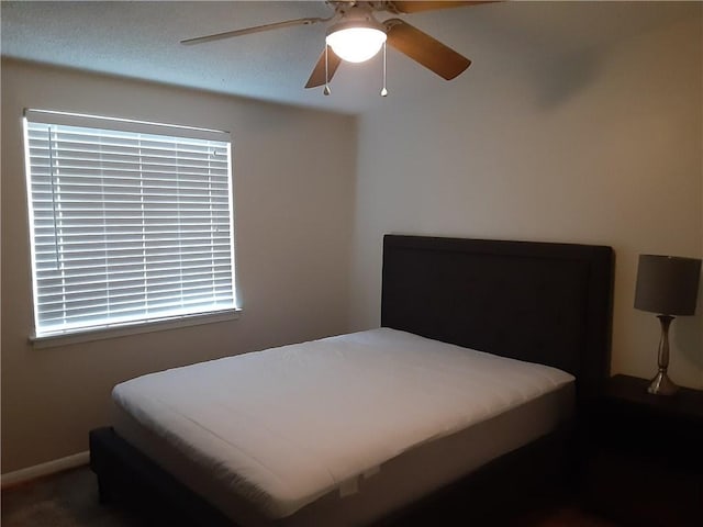 bedroom with baseboards and a ceiling fan