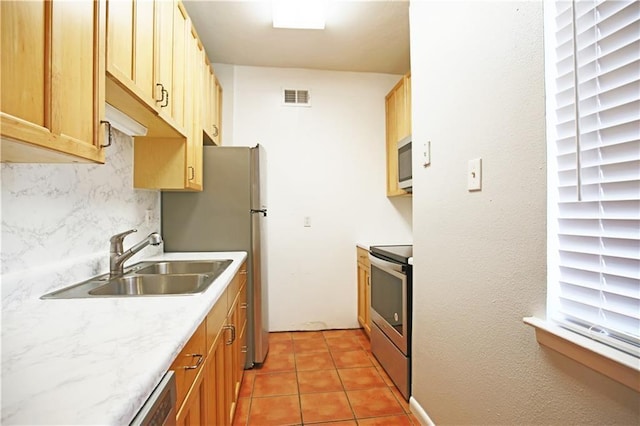 kitchen with a sink, visible vents, decorative backsplash, light countertops, and appliances with stainless steel finishes