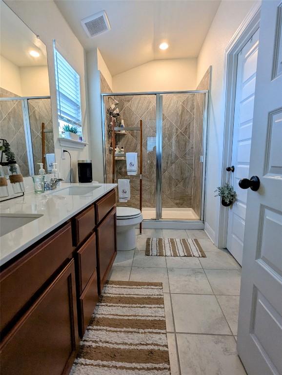 7617 Rio Pass, Austin, TX 78724 - bathroom featuring a shower stall, double vanity, and tile patterned floors