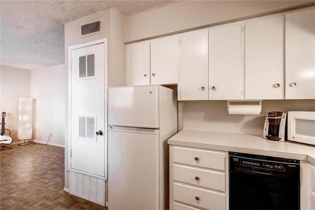 803 W 28th St Unit 105, Austin, TX 78705 - kitchen with white cabinets, a textured ceiling, visible vents, white appliances, and light countertops