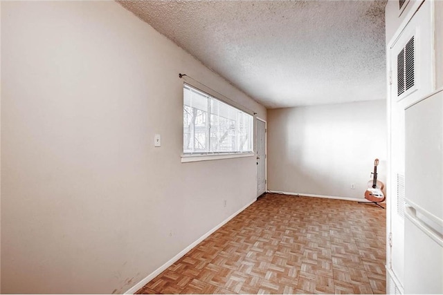 803 W 28th St Unit 105, Austin, TX 78705 - spare room featuring a textured ceiling and baseboards