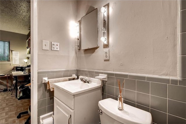 803 W 28th St Unit 105, Austin, TX 78705 - bathroom with tile walls, toilet, vanity, and a wainscoted wall