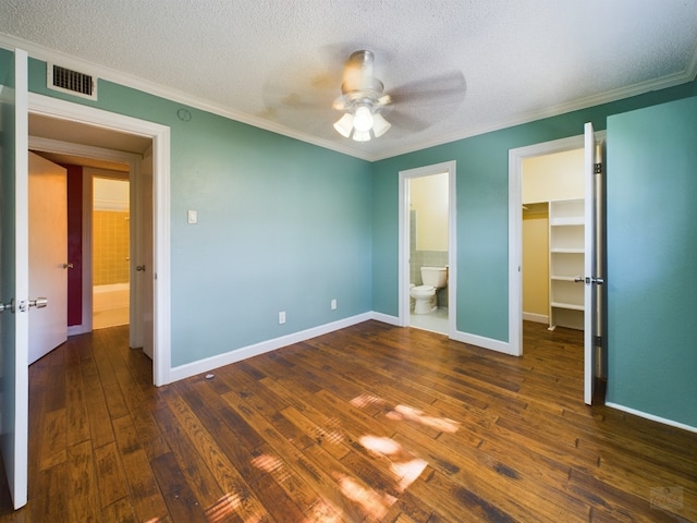 803 W 28th St Unit 206, Austin, TX 78705 - unfurnished bedroom featuring a spacious closet, dark wood-style flooring, a textured ceiling, crown molding, and a closet