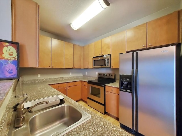 2502 Leon St Unit 515, Austin, TX 78705 - kitchen with a sink, stainless steel appliances, light wood finished floors, light countertops, and light brown cabinets