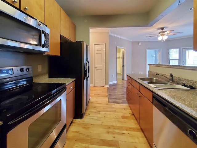 2502 Leon St Unit 515, Austin, TX 78705 - kitchen with light wood-style flooring, ceiling fan, a sink, crown molding, and appliances with stainless steel finishes