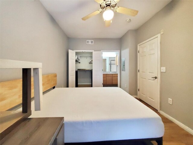 2502 Leon St Unit 515, Austin, TX 78705 - bedroom with wood finished floors, visible vents, a ceiling fan, a walk in closet, and baseboards
