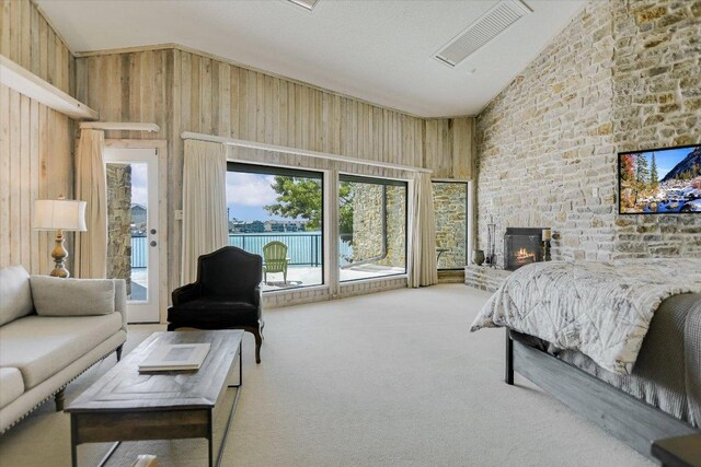 402 Island Dr Unit C, Horseshoe Bay, TX 78657 - carpeted bedroom featuring vaulted ceiling, a large fireplace, wood walls, and access to outside