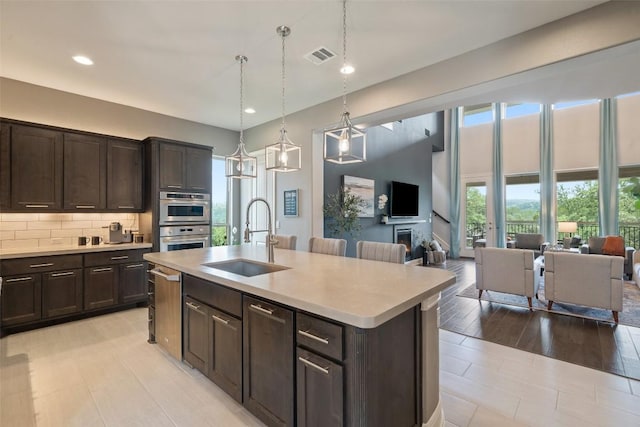 1300 Morning Moon Cir, Austin, TX 78732 - kitchen featuring open floor plan, stainless steel appliances, dark brown cabinetry, light countertops, and recessed lighting