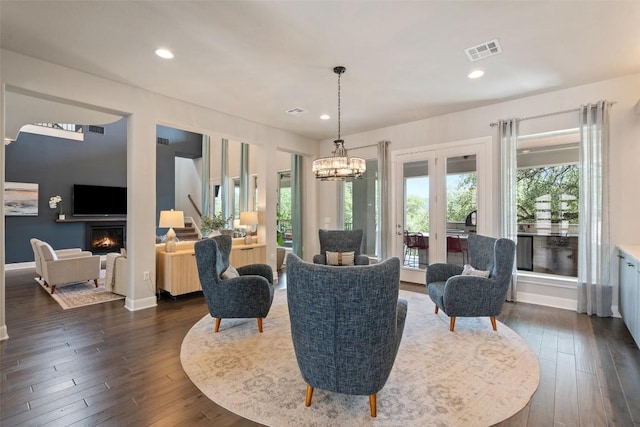 1300 Morning Moon Cir, Austin, TX 78732 - living area featuring dark wood-style flooring, recessed lighting, a warm lit fireplace, a chandelier, and french doors
