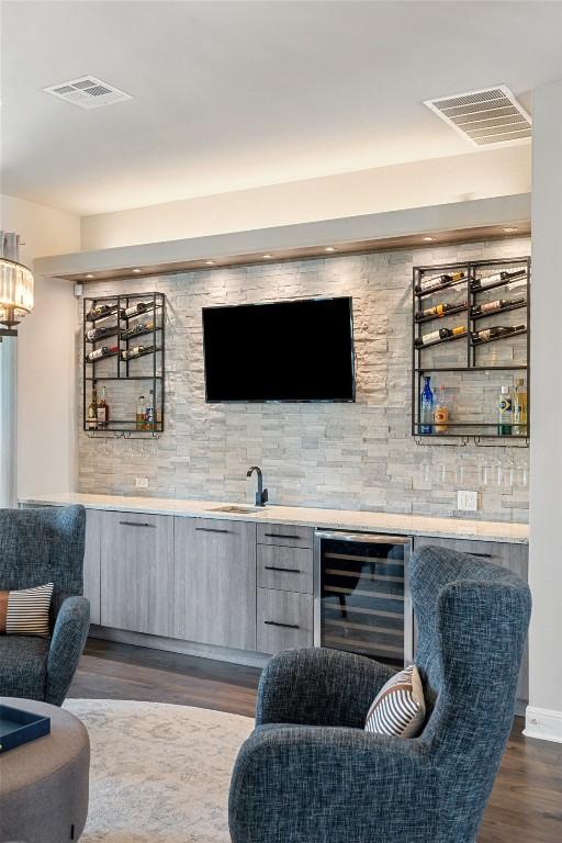 1300 Morning Moon Cir, Austin, TX 78732 - indoor wet bar with wine cooler, dark wood-type flooring, and backsplash