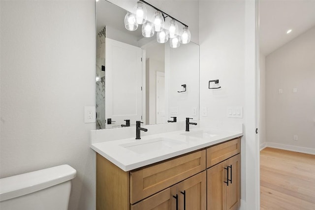 6309 Friendswood Dr, Austin, TX 78723 - full bathroom with toilet, double vanity, wood finished floors, and baseboards