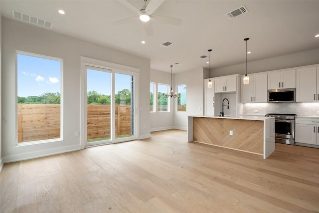 6309 Friendswood Dr, Austin, TX 78723 - kitchen featuring appliances with stainless steel finishes, backsplash, light wood-style flooring, light countertops, and a ceiling fan