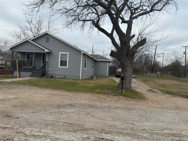 211 Murphy St, Taylor, TX 76574 - view of side of home with a porch, driveway, and a lawn