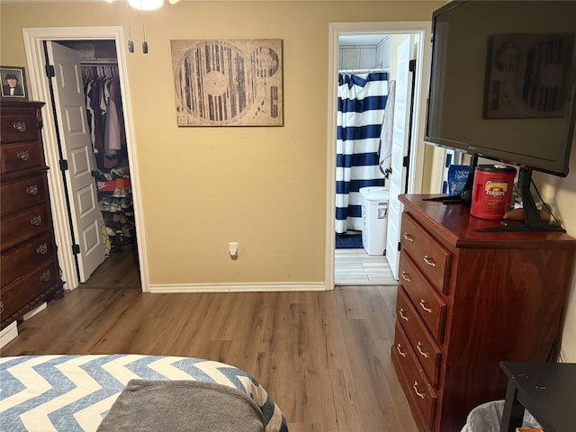 211 Murphy St, Taylor, TX 76574 - bedroom with wood finished floors, baseboards, a spacious closet, a closet, and ensuite bath