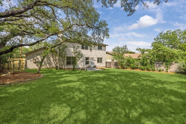 back of property with a lawn and a fenced backyard