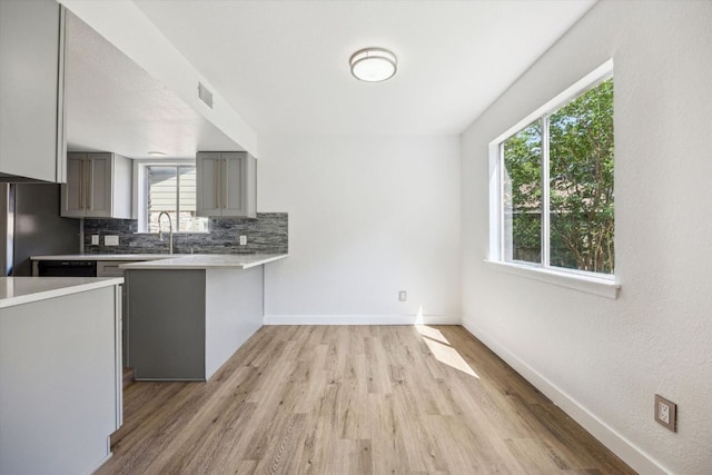 kitchen with gray cabinetry, light countertops, and a healthy amount of sunlight