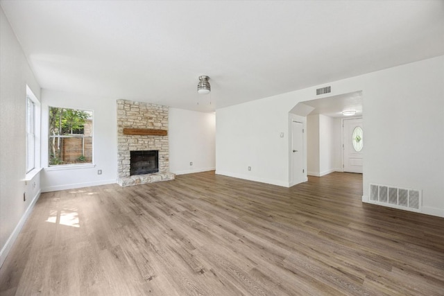 4525 Langtry Ln, Austin, TX 78749 - unfurnished living room with wood finished floors, a stone fireplace, and arched walkways