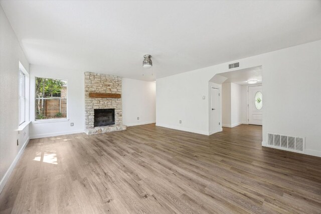 4525 Langtry Ln, Austin, TX 78749 - unfurnished living room with wood finished floors, a fireplace, a ceiling fan, and arched walkways