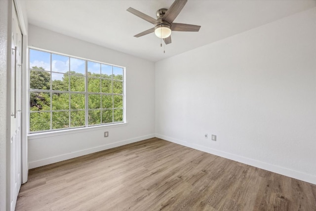 unfurnished room with a ceiling fan, wood finished floors, and baseboards