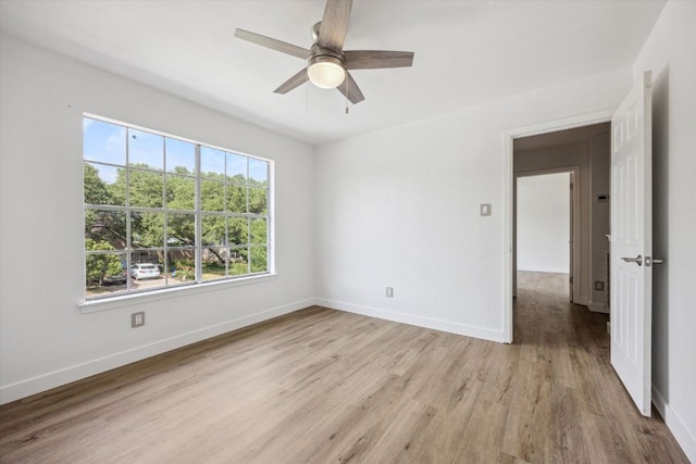 spare room with light wood-type flooring, baseboards, and ceiling fan