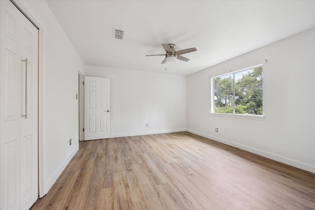 unfurnished bedroom featuring ceiling fan, baseboards, visible vents, and light wood-style floors