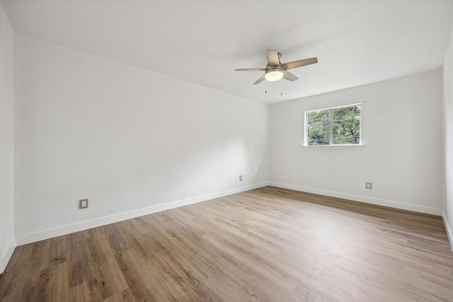 empty room with baseboards, a ceiling fan, and wood finished floors
