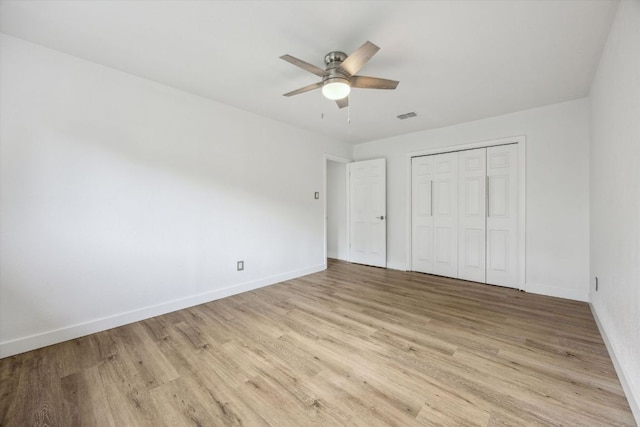 unfurnished bedroom with baseboards, light wood finished floors, and visible vents