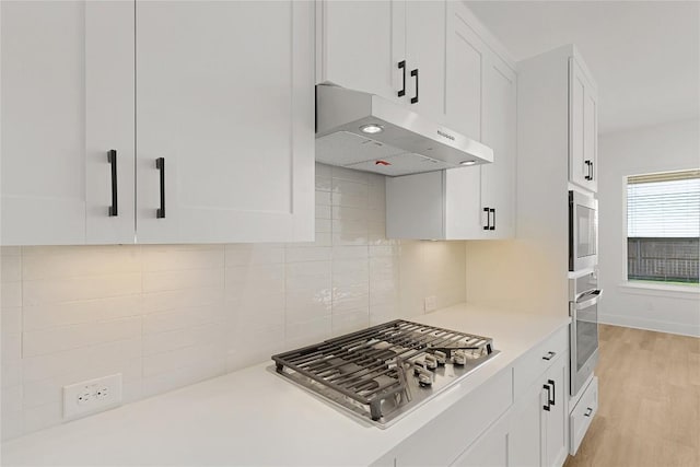 505 Golden Sage Ave, Georgetown, TX 78633 - kitchen with under cabinet range hood, stainless steel appliances, and white cabinets