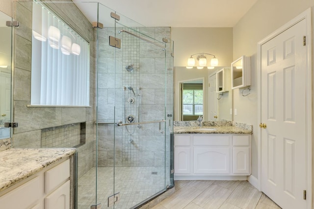 bathroom featuring a shower stall, vanity, a chandelier, and tile patterned floors