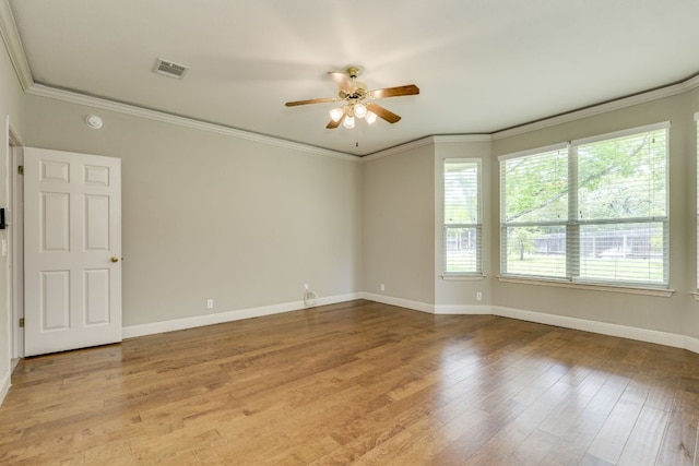 empty room featuring a ceiling fan, baseboards, ornamental molding, and wood finished floors