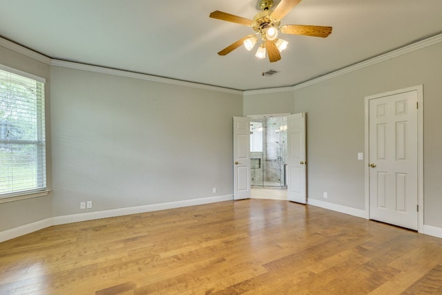 unfurnished bedroom featuring multiple windows, ornamental molding, baseboards, light wood-style flooring, and connected bathroom