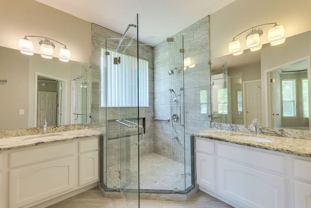full bath with a shower stall and two vanities