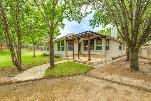 view of front of house featuring a pergola, a chimney, and a patio