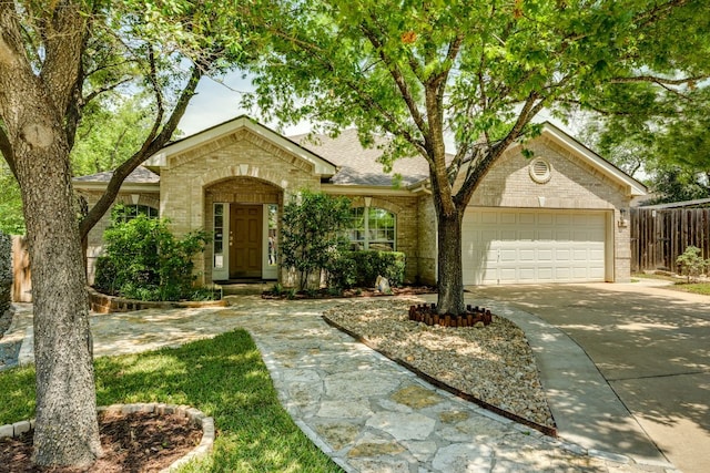 view of front of house featuring brick siding, concrete driveway, an attached garage, fence, and roof with shingles