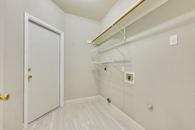 laundry area with hookup for a washing machine and baseboards