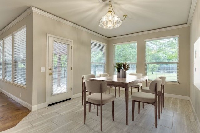 dining space featuring a chandelier, baseboards, ornamental molding, plenty of natural light, and light wood-style floors