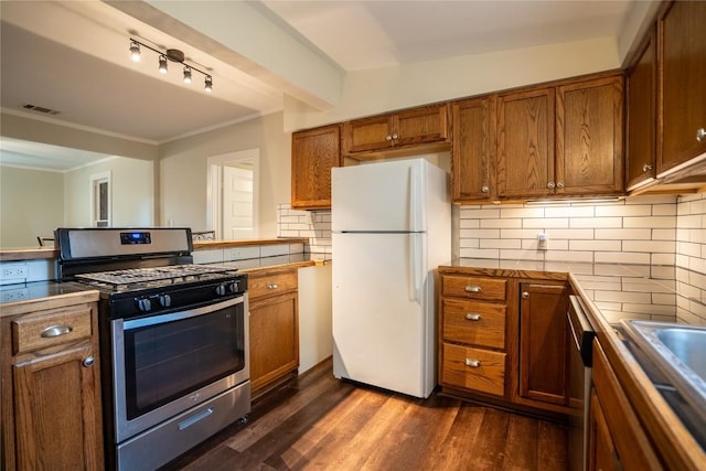 kitchen featuring brown cabinetry, stainless steel appliances, visible vents, and dark wood-type flooring