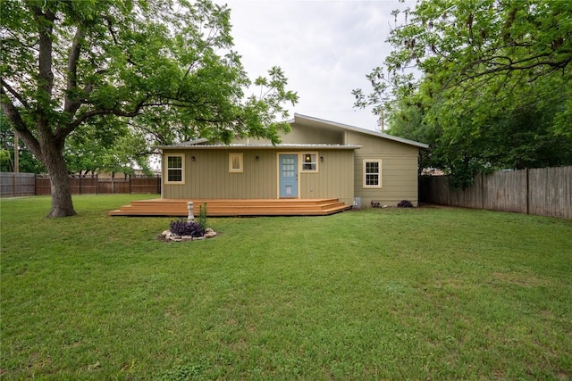 back of house with a fenced backyard, a wooden deck, and a yard