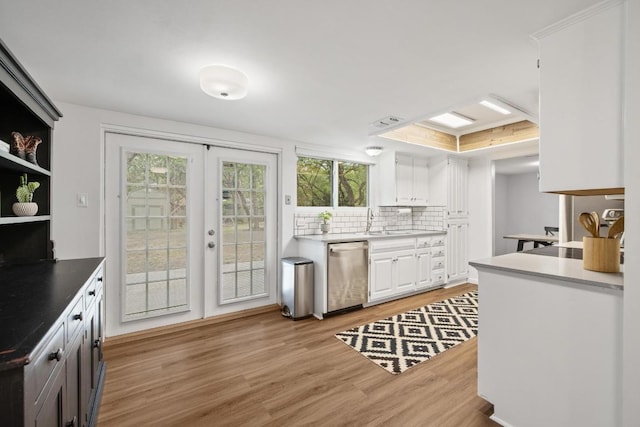 105 S Rainbow Bridge Dr, Cedar Park, TX 78613 - kitchen featuring stainless steel dishwasher, light wood-style flooring, white cabinetry, tasteful backsplash, and healthy amount of natural light
