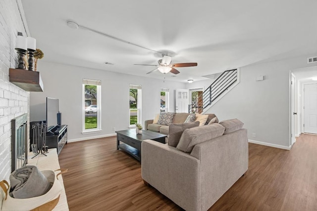 105 S Rainbow Bridge Dr, Cedar Park, TX 78613 - living area featuring dark wood-style floors, a fireplace, ceiling fan, and healthy amount of natural light