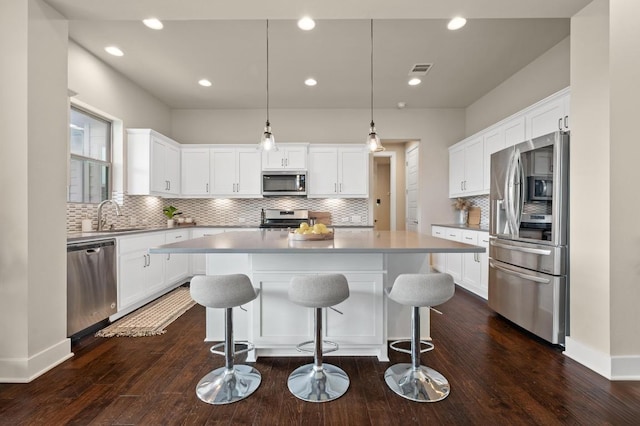 6800 Idea Rd, Austin, TX 78741 - kitchen featuring a sink, white cabinets, a center island, and appliances with stainless steel finishes