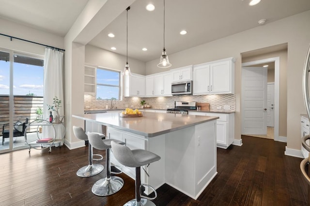 6800 Idea Rd, Austin, TX 78741 - kitchen featuring backsplash, appliances with stainless steel finishes, a kitchen island, and a breakfast bar