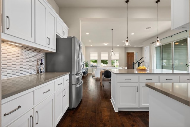 6800 Idea Rd, Austin, TX 78741 - kitchen with stainless steel fridge with ice dispenser, white cabinetry, dark wood-style floors, backsplash, and recessed lighting