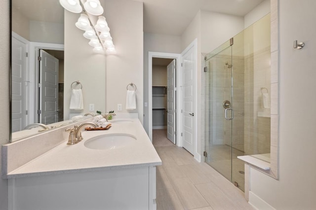 6800 Idea Rd, Austin, TX 78741 - bathroom featuring a stall shower, a spacious closet, double vanity, and a sink