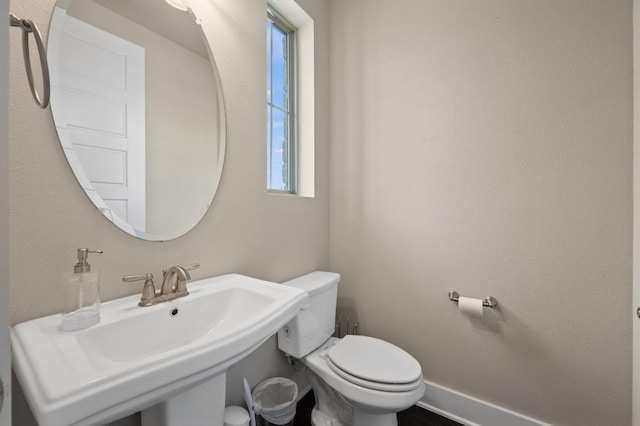 6800 Idea Rd, Austin, TX 78741 - half bathroom featuring toilet, baseboards, and a sink