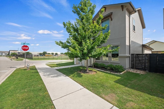 6800 Idea Rd, Austin, TX 78741 - view of property exterior featuring fence, stucco siding, and a lawn