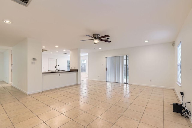1171 Southern Pl, Round Rock, TX 78665 - unfurnished living room featuring recessed lighting, a wealth of natural light, ceiling fan, light tile patterned flooring, and a sink
