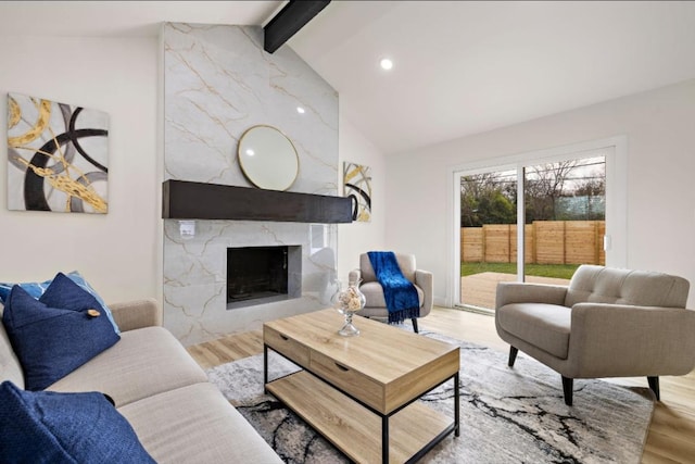 living room featuring high vaulted ceiling, a high end fireplace, beam ceiling, and wood finished floors