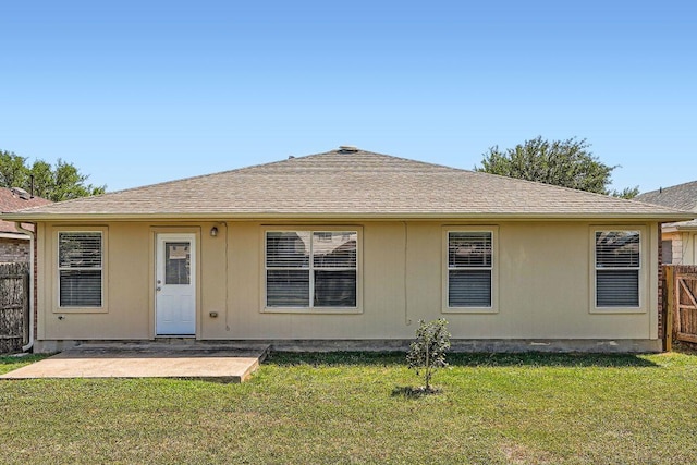 back of property featuring a patio area, roof with shingles, fence, and a lawn