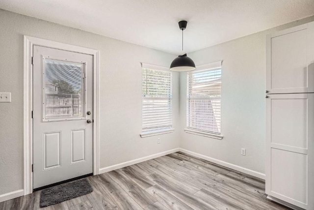 305 Bird Dog Bnd, Bastrop, TX 78602 - unfurnished dining area featuring light wood-style flooring and baseboards